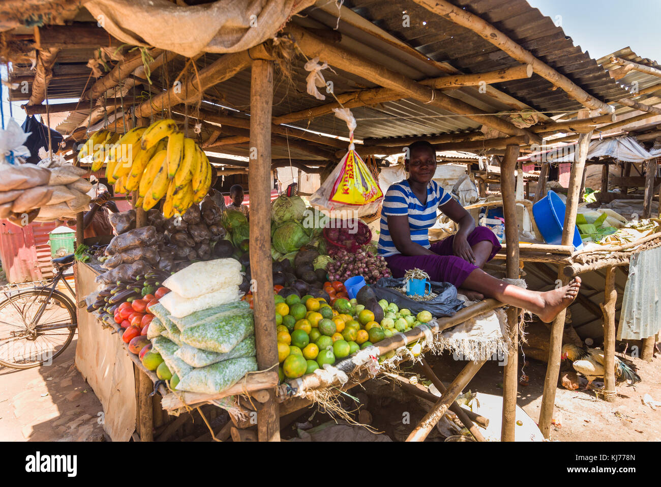 Afrikanische ugandische Frau sitzen im Schatten der ihr Obst und Gemüse auf einem Markt, Uganda, Afrika Stockfoto