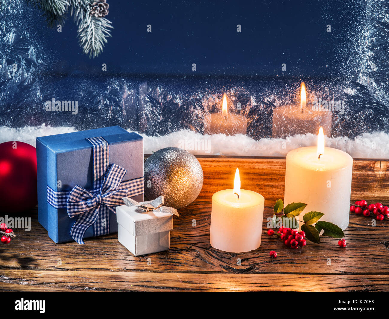 Geschenkboxen, Kerzenlicht und gefrorenen Fenster. Weihnachten Hintergrund. Stockfoto