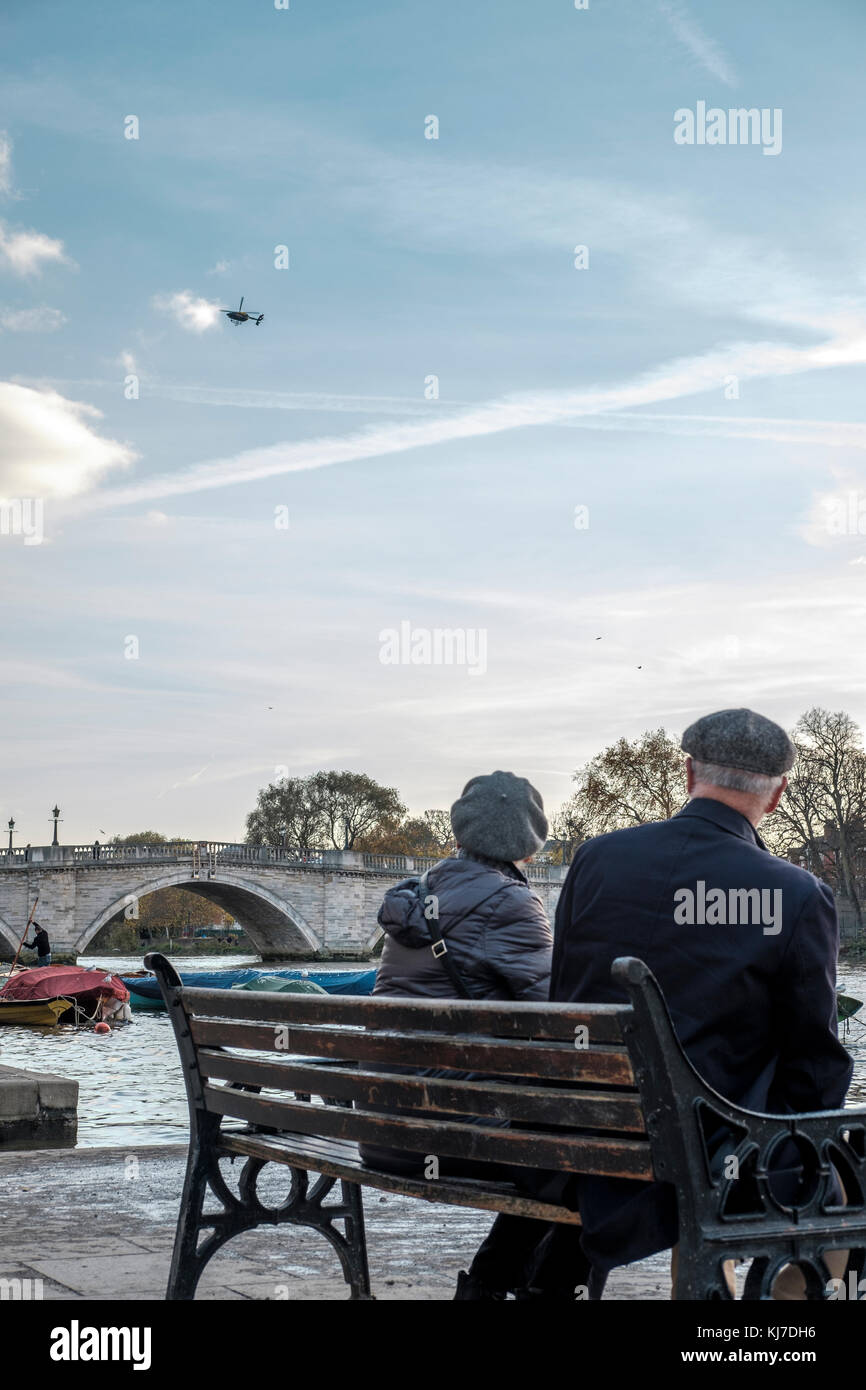 Richmond upon Thames, Großbritannien - Paar mittleren Alters beobachten ein Polizeihubschrauber schwebt über Richmond Bridge Stockfoto