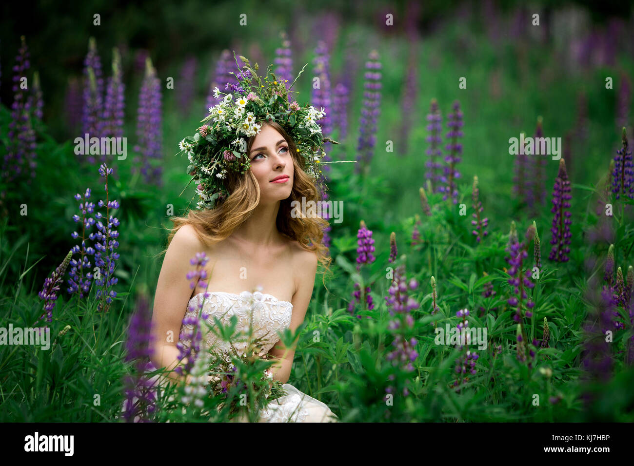 Frau in weißem Kleid in Lupin Feld Stockfoto