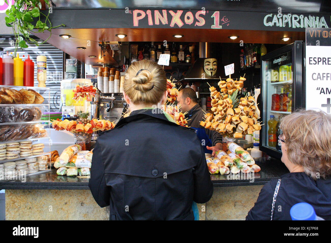 Touristen und Einkaufsmöglichkeiten für Lebensmittel und Gemüse auf dem Bauernmarkt in Barcelona suchen Stockfoto