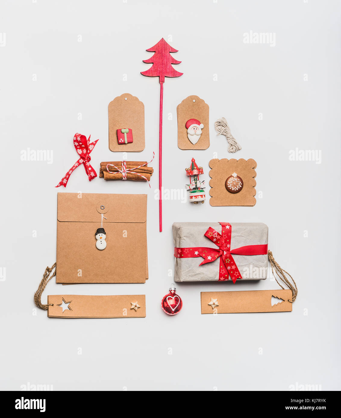 Weihnachtsbaum Layout mit Handwerk Papier Verpackung Geschenkboxen, Tags, Spielzeug, rot Urlaub Dekoration und Gewürzen auf weißem Schreibtisch Hintergrund, Ansicht von oben, Fla Stockfoto