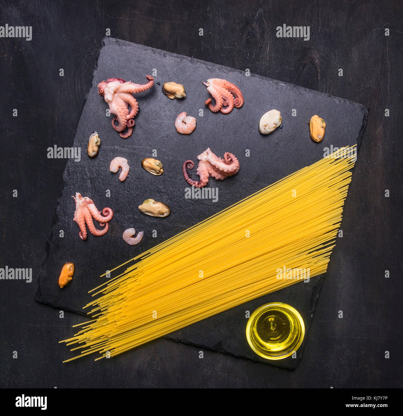 Konzept der kochen Pasta mit Meeresfrüchten, Tintenfisch, Tintenfisch, Muscheln und Garnelen sind auf einem Schneidebrett mit Butter Draufsicht gezeichnet Stockfoto