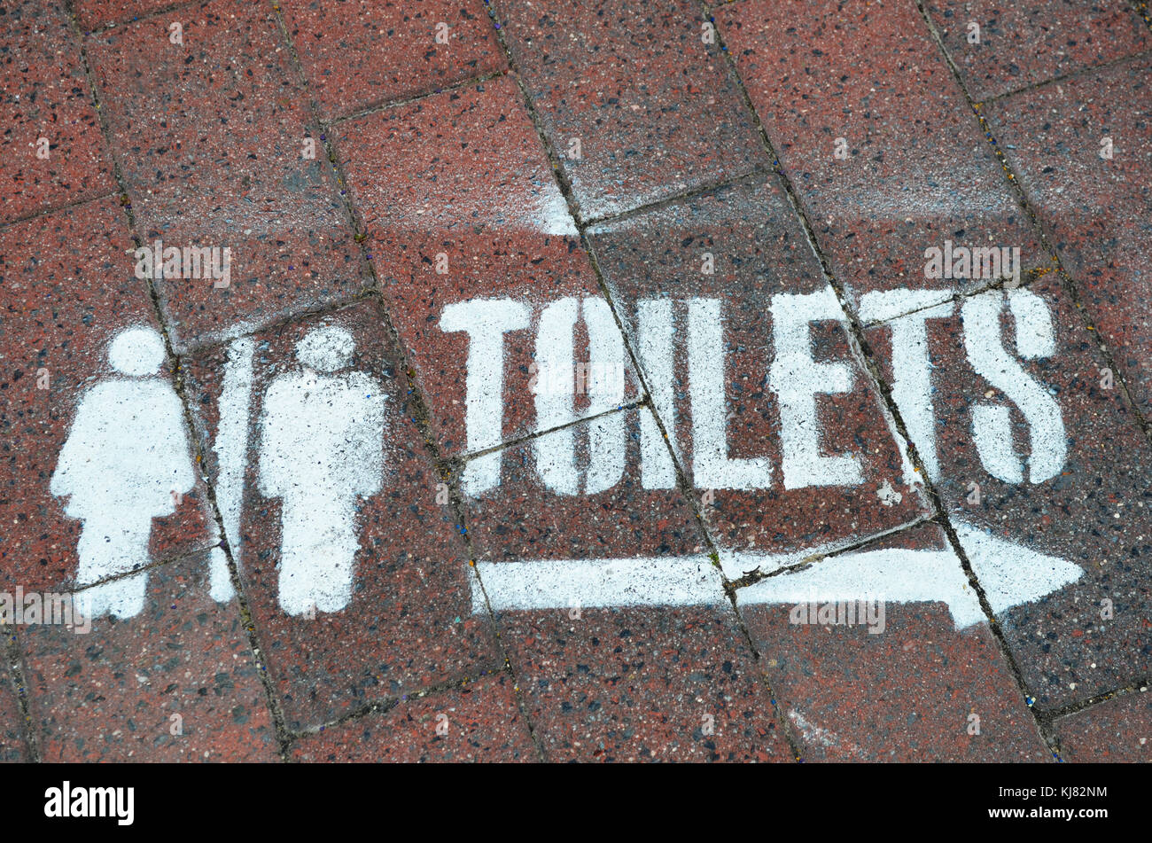 Zeichen in Richtung zur Toilette Spray auf Gehweg in der Straße am Eingang nsw Australien lackiert Stockfoto