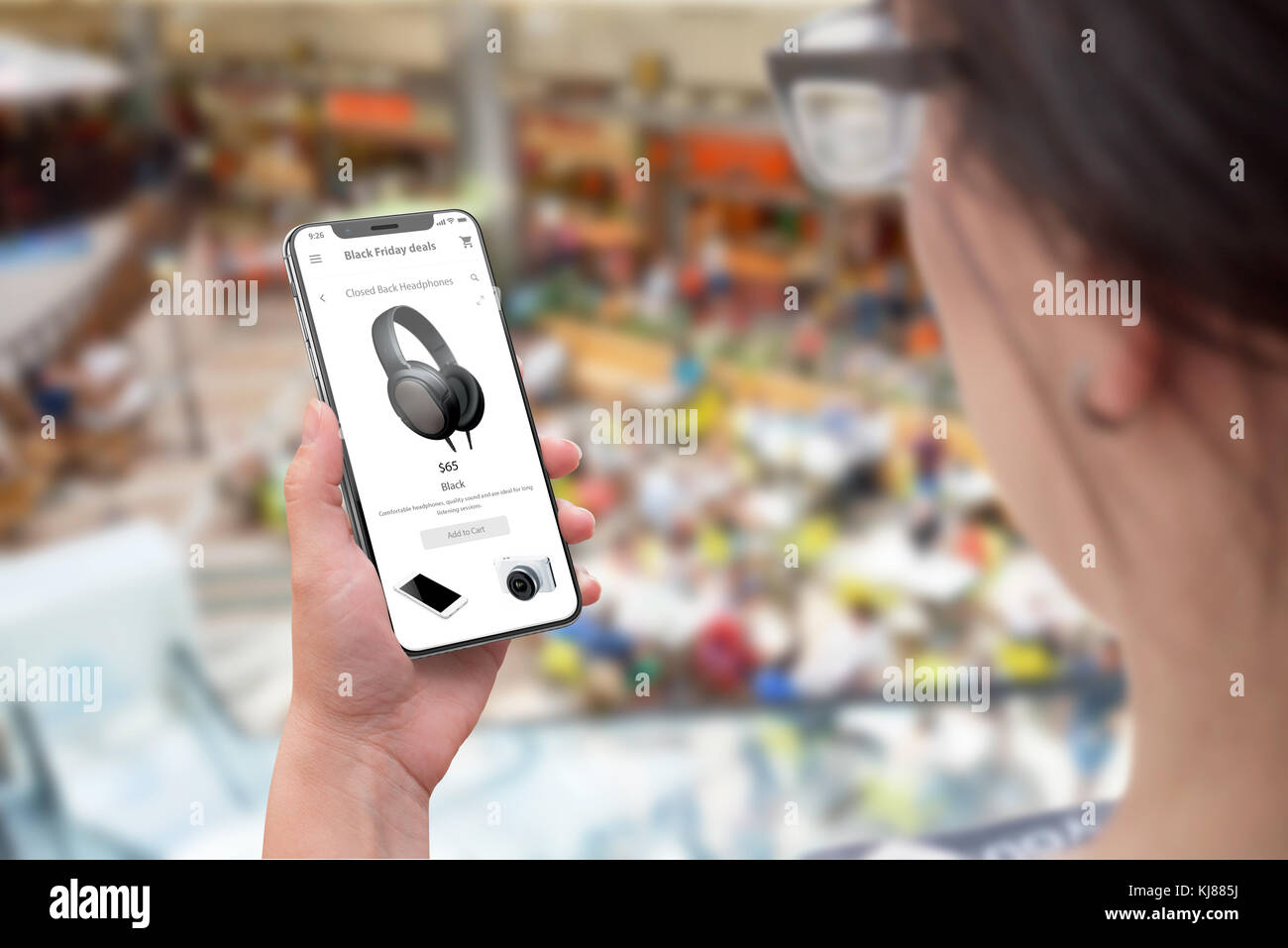 Einkaufen mit dem Handy. Online Discount am schwarzen Freitag Verkauf. Frau mit Handy. Shopping Mall im Hintergrund. Stockfoto
