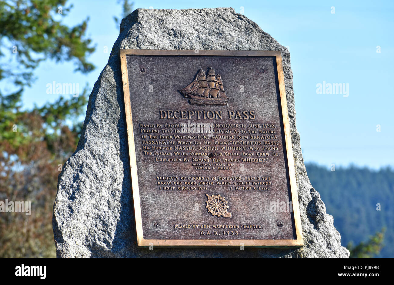 Bronze Zeichen beschreiben Deception Pass und wie wurde es von Kapitän George Vancouver benannt. Stockfoto