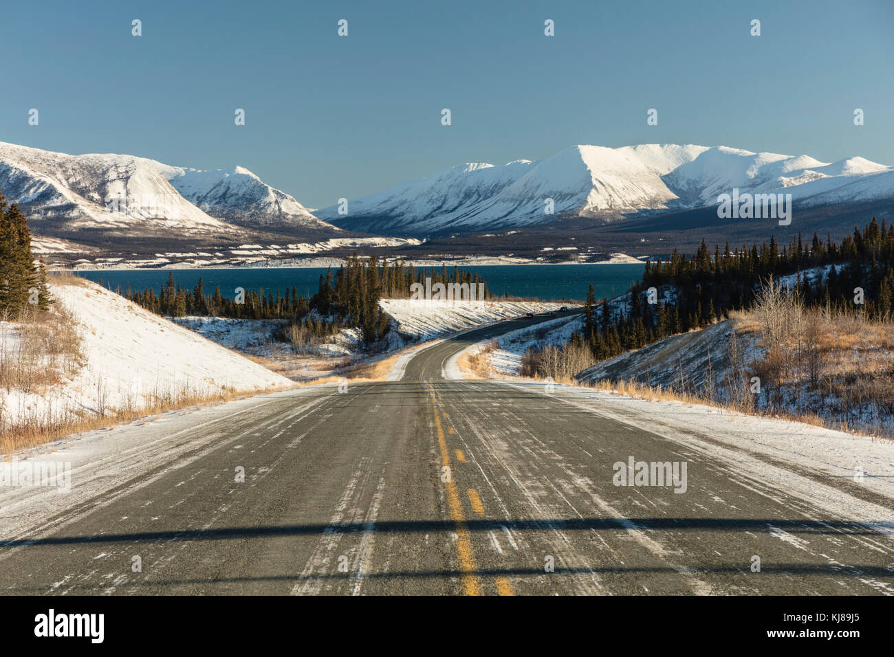 Der Alaska Highway schlängelt sich am Kluane Lake und den Ruby Range Bergen im Yukon Territory vorbei. Stockfoto