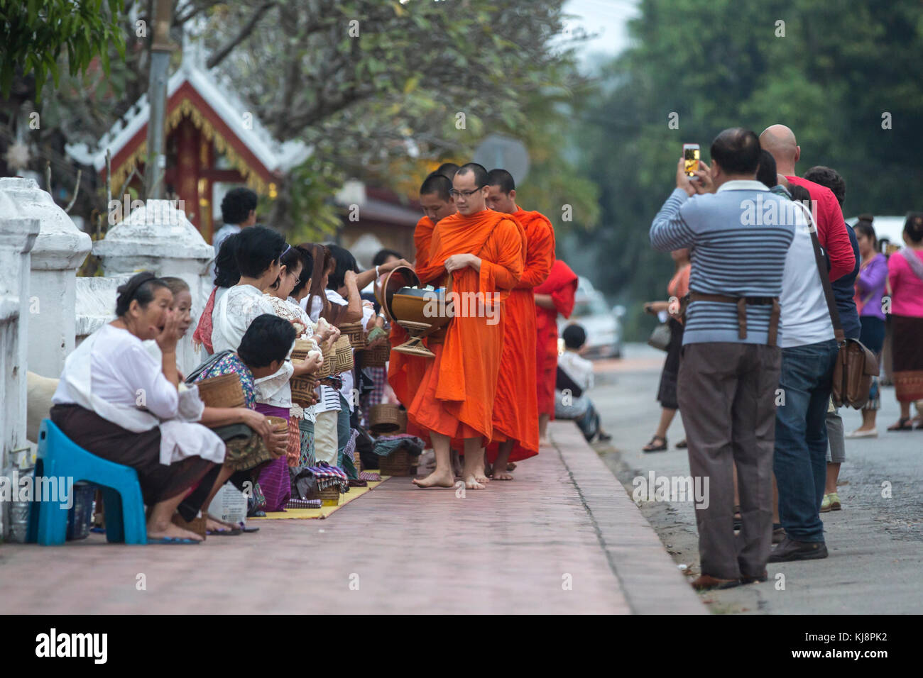 Luang Prabang, Laos - 19. November 2017: Toristen fotografieren buddhistische Mönche jeden Morgen traditionelle Almosengaben in Luang Prabang, Laos. Stockfoto