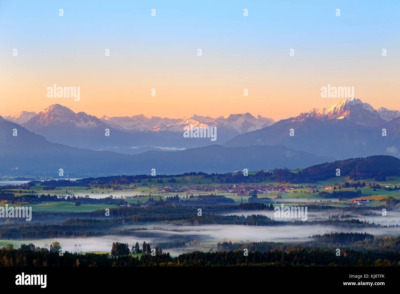 Früher Nebel im Tal bei Sonnenaufgang, Blick von Auerberg bei Bernbeuren, Dorf Roßhaupten, Lechtaler Alpen und Gehrenspitze Stockfoto