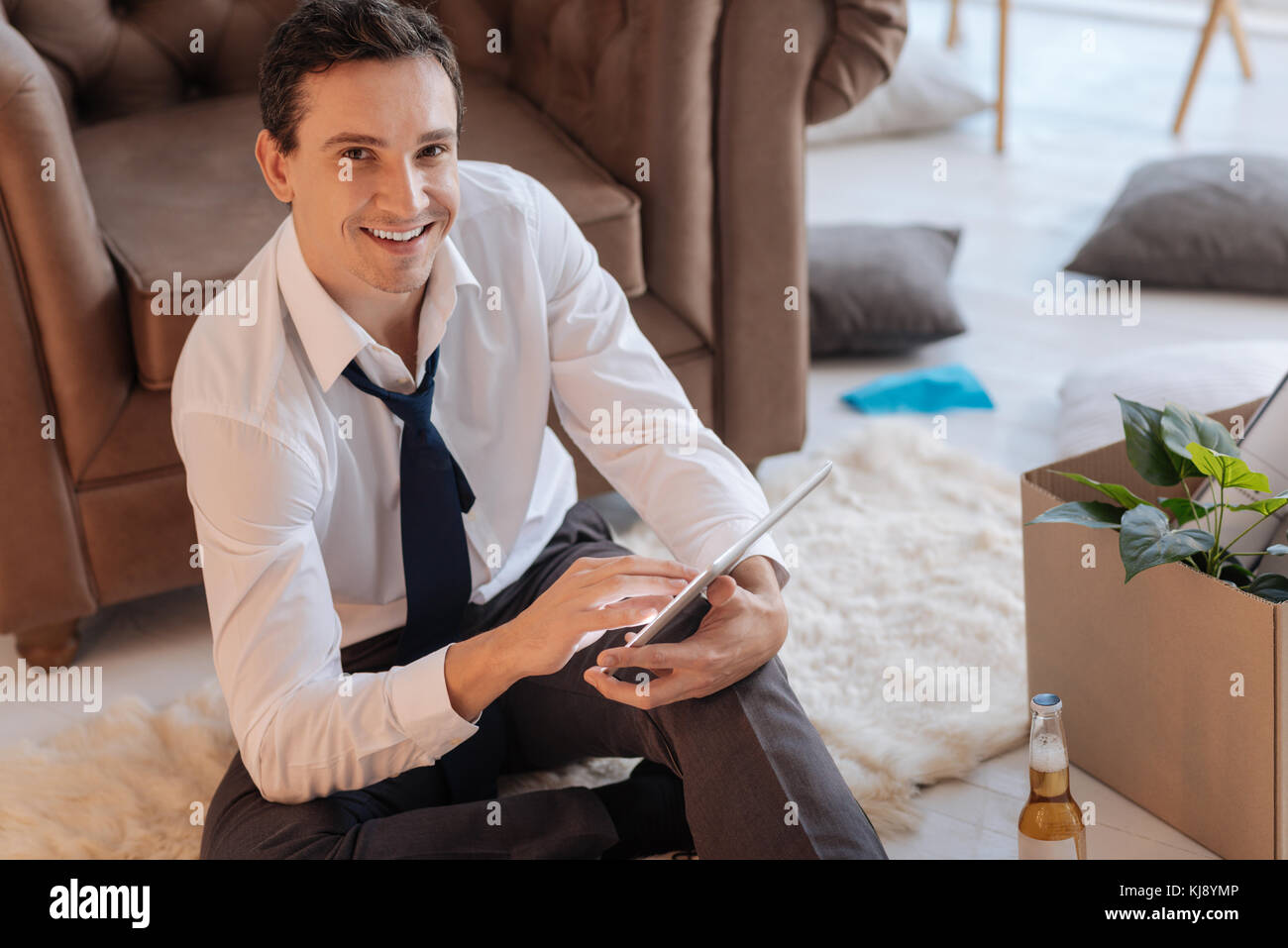 Freundlich lächelnden Mann sitzt mit einem modernen Tablet Stockfoto