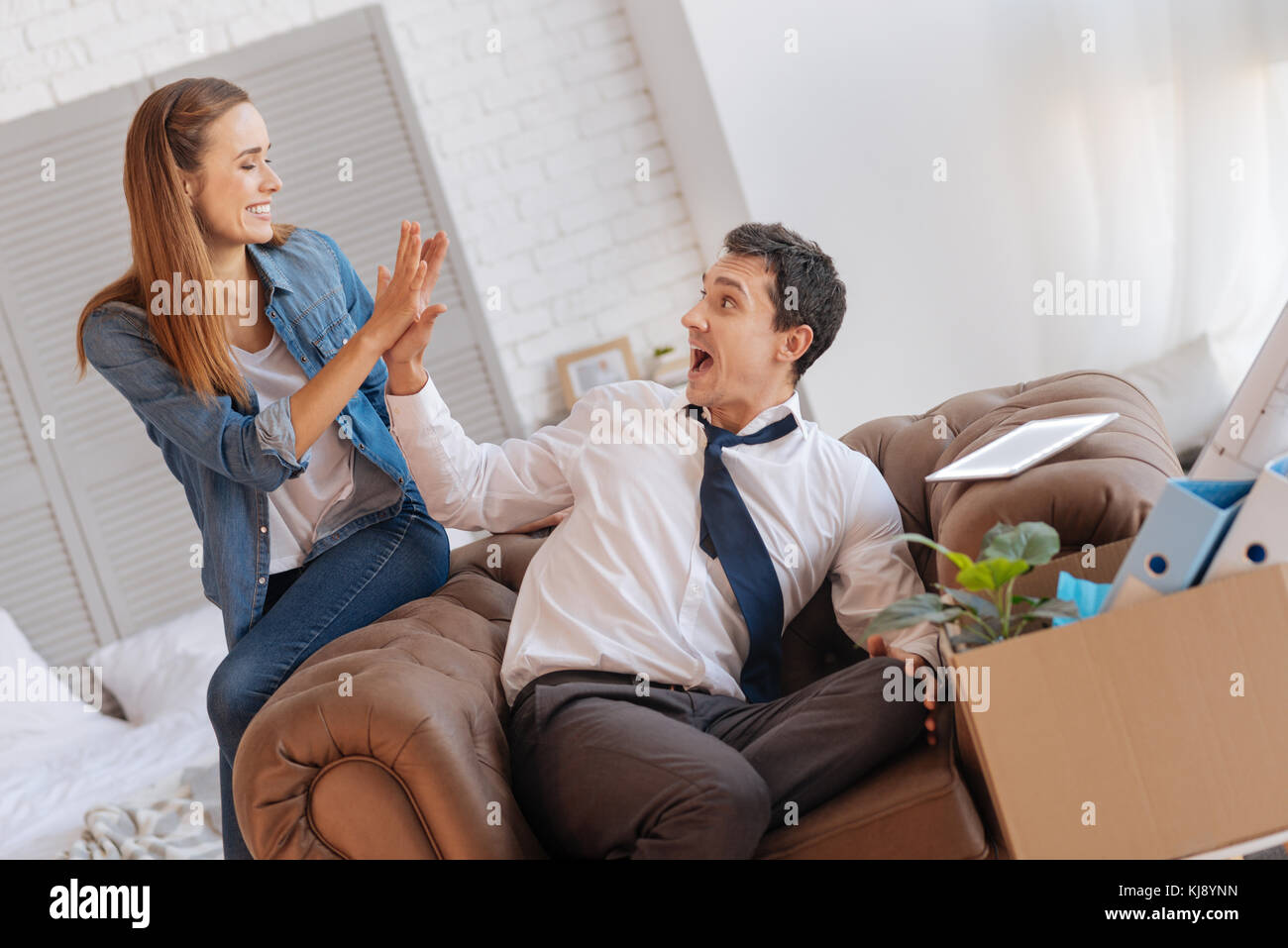 Aufgeregt eleganten Mann fünf zu geben, seine fröhliche Frau Stockfoto