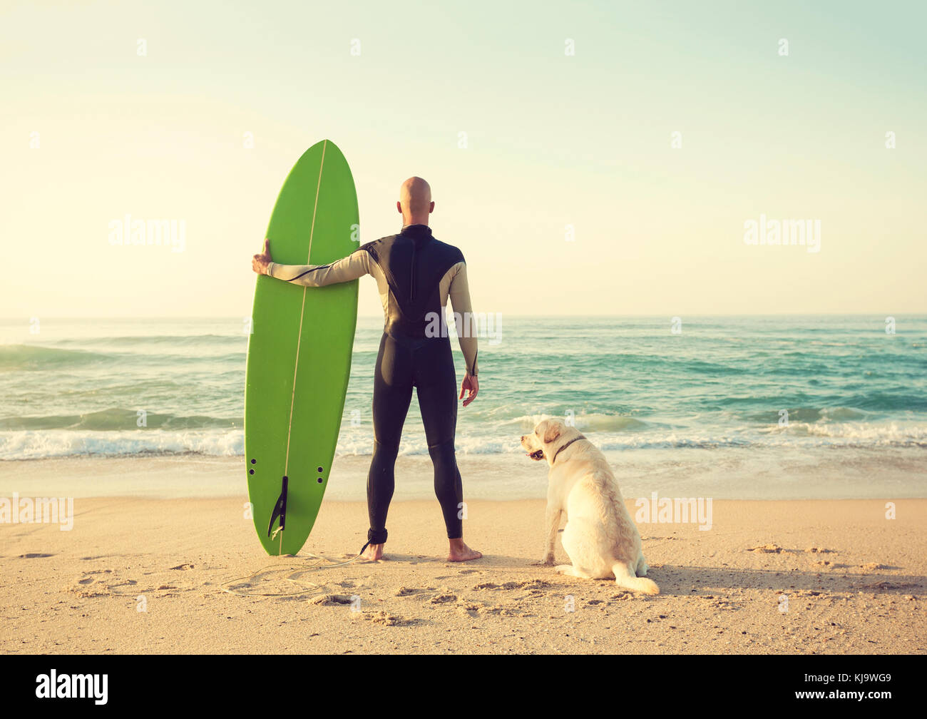 Surfist am Strand mit seinem besten Freund Stockfoto