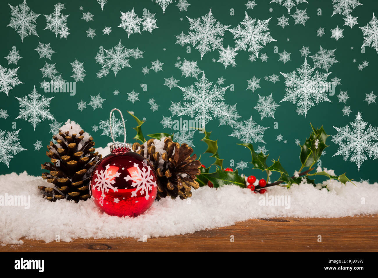 Weihnachtskugel Stillleben mit Tannenzapfen Holly und Schneeflocken. Stockfoto