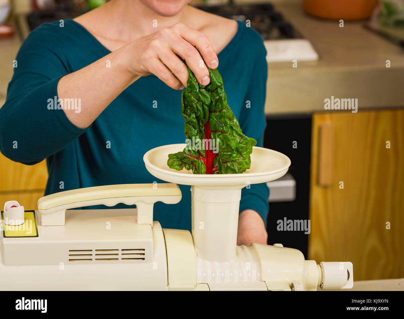Frau mit einer Zentrifuge Maschine a detox Saft vorzubereiten. Stockfoto