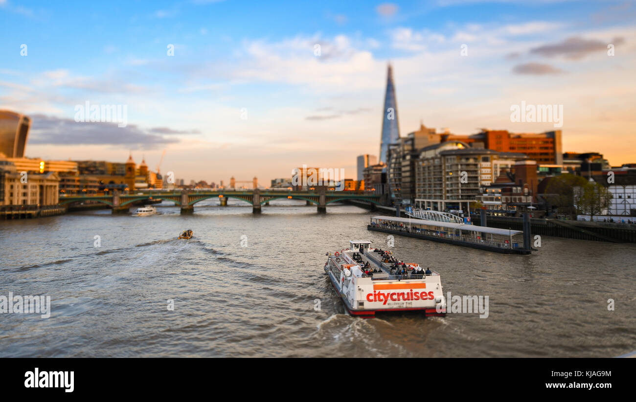 Anzeigen von Millennium Fußgängerbrücke in Richtung der Shard und Tower Bridge mit City Cruises Yacht Passing auf der Themse. Mit Tilt Shift Effekt. Stockfoto