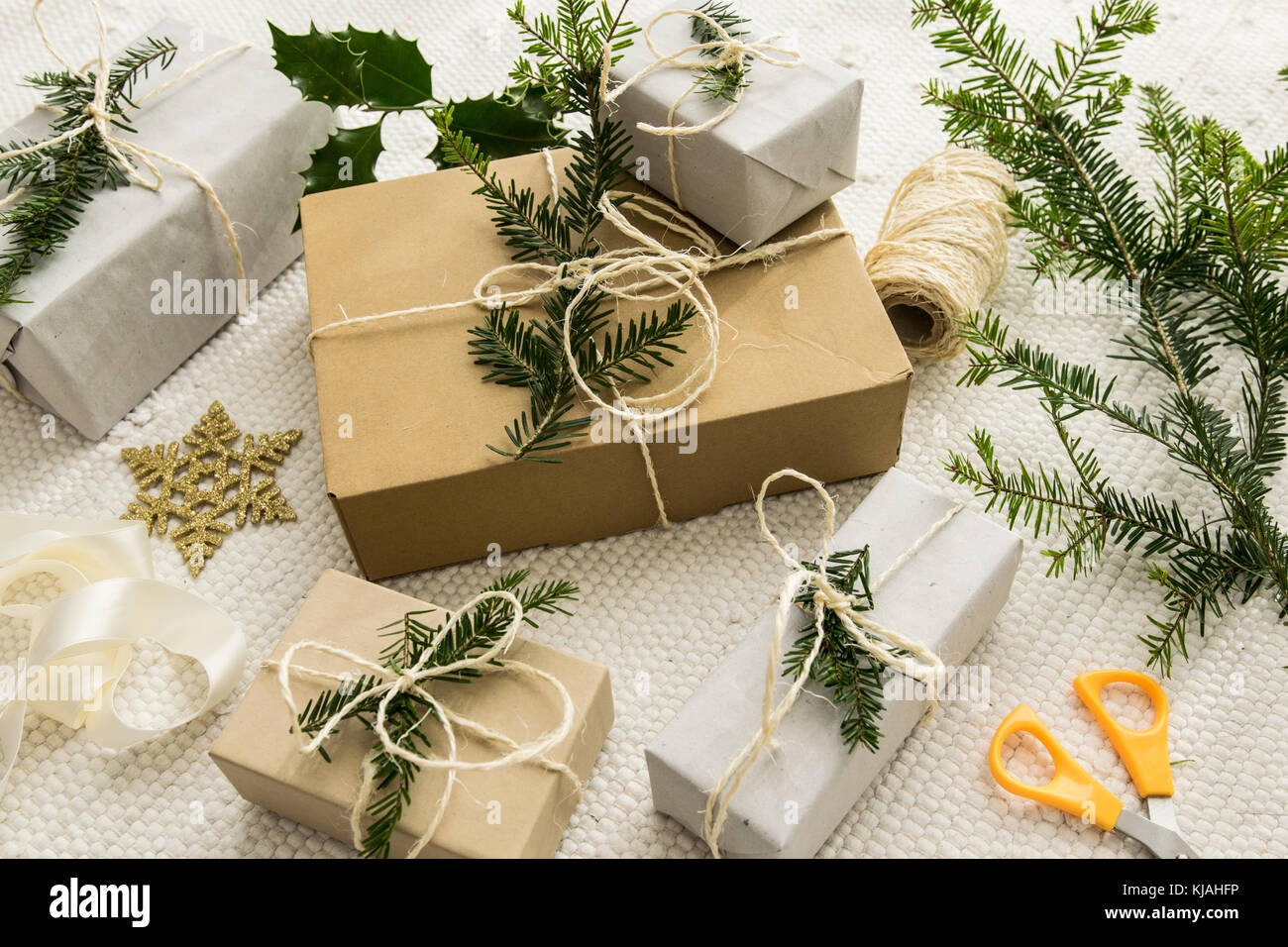 Weihnachtsgeschenke eingepackt und mit Zweigen dekoriert Stockfoto