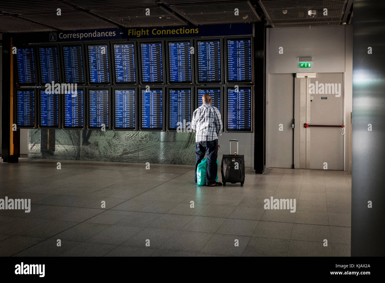 Ein Mann schaut auf die Flugverbindungen in Paris Charles de Gaulle, aka Roissy Airport in Frankreich. Stockfoto
