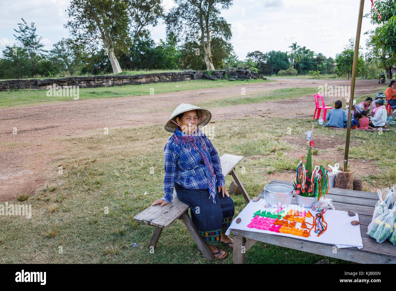 Lokale Lebensstil: alte Frau tendenziell einen Stall mit Souvenirs und Schmuck an die längst vergangene angkorianische Khmer Hindu Tempel von Wat Phou, Champasak, Süd Laos Stockfoto