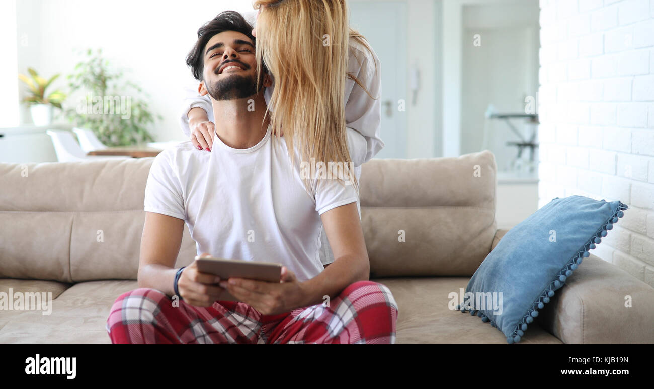 Nettes Paar entspannen auf der Couch mit Tablette zu Hause Stockfoto
