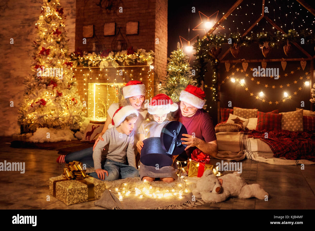 Die Familie stellt in einem Zimmer am Weihnachtstag. Stockfoto