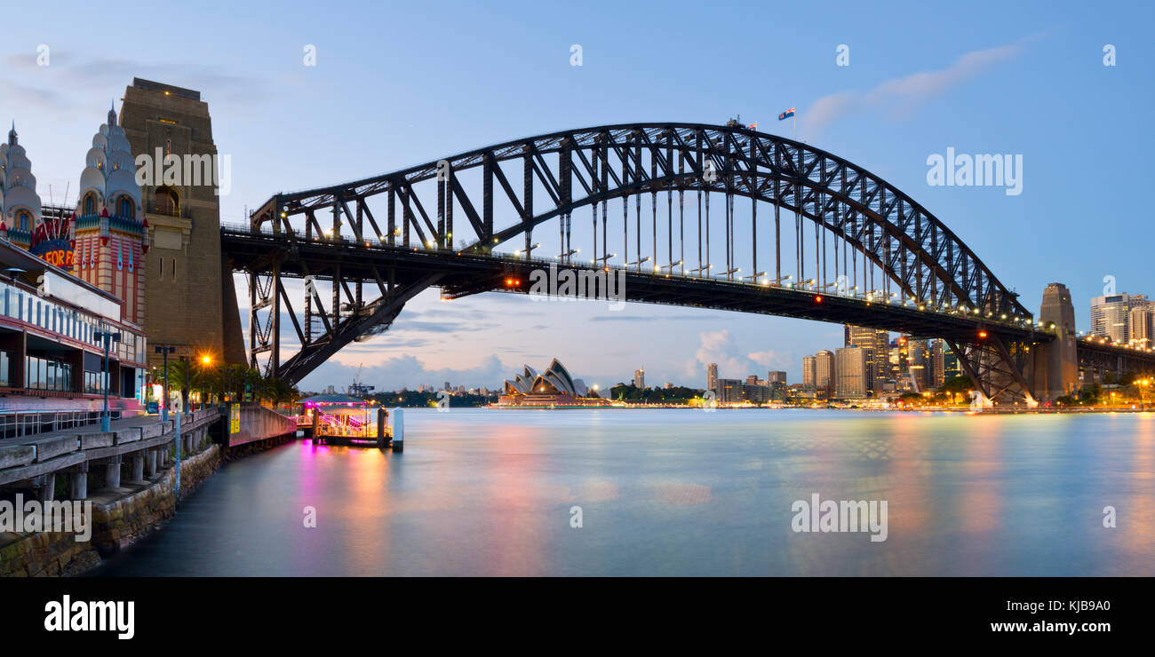 Panorama Fotografie auf die Harbour Bridge und das Opernhaus von Sydney vom Luna Park in Milsons Point, Sydney, NSW, Australien kurz vor Sonnenaufgang. Stockfoto