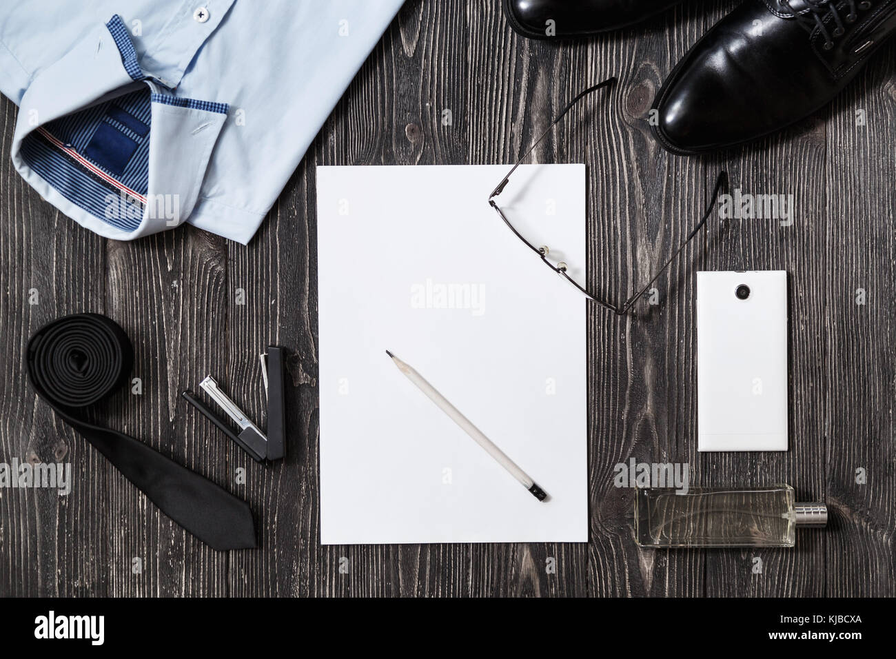 Der Geschäftsmann Mode Accessoires und leeres Papier in der Mitte, in der Ansicht von oben auf weißem Holz- Hintergrund Stockfoto