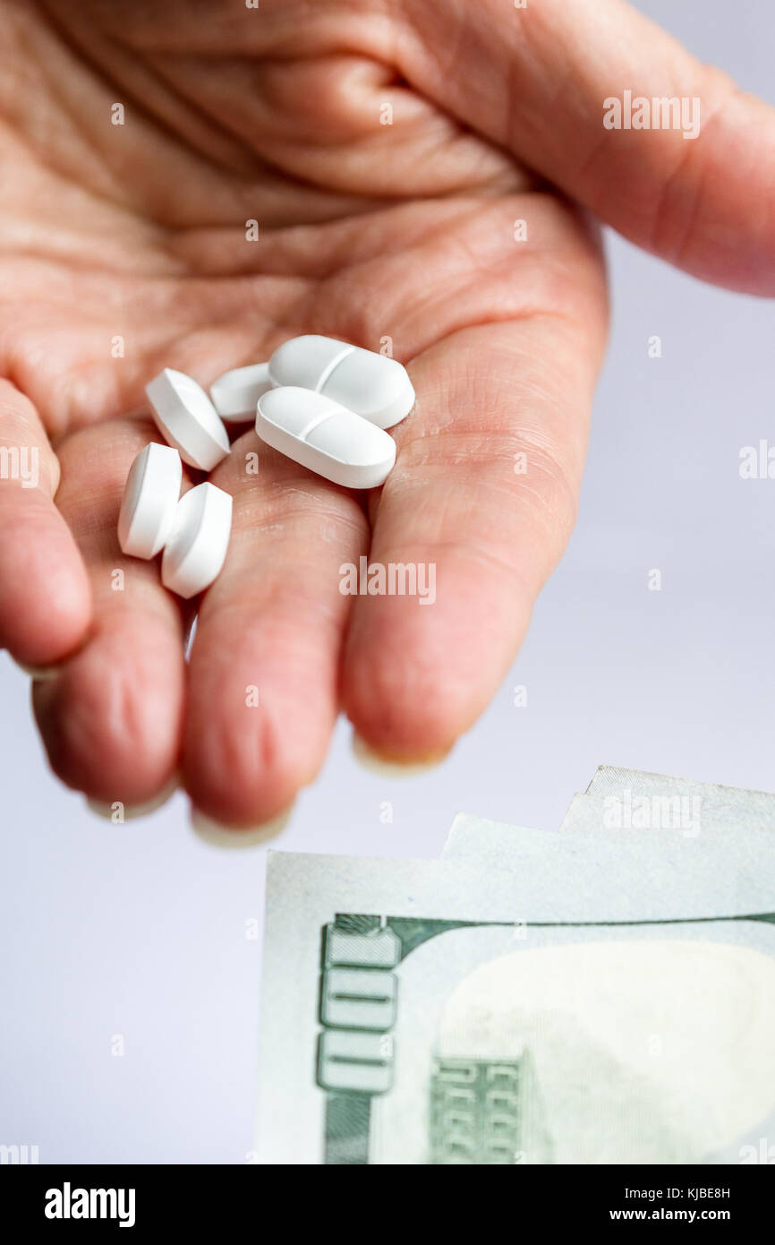 Hände, die schmerzmittel Verschreibung von Opioiden und eine andere Hand Übergabe drei hundert US-Dollarnoten Stockfoto