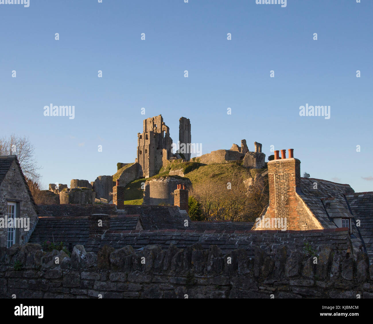 Die Ruinen von Corfe Castle über die Dächer vom Bahnhof gesehen Stockfoto