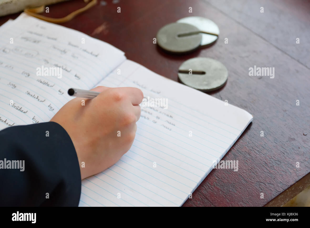 Schule Wissenschaft Kategorie mit der Aufnahme der Schüler Ergebnisse im Notebook Gewichte Massen für die hooke Gesetz experiment Stockfoto