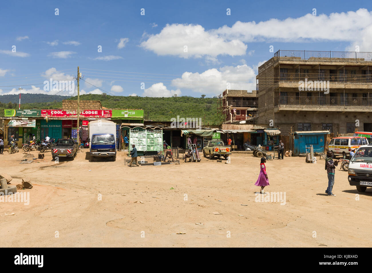 Eine Ansicht von Mai Mahiu Stadt mit Leuten über das tägliche Leben mit Gebäuden und Geschäften im Hintergrund gehen, Kenia Stockfoto