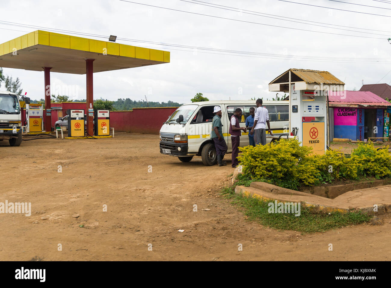 Typische afrikanische kleine Tankstelle mit einem Matatu Minibus und Menschen füllt sich mit Kraftstoff, Kenia, Ostafrika Stockfoto