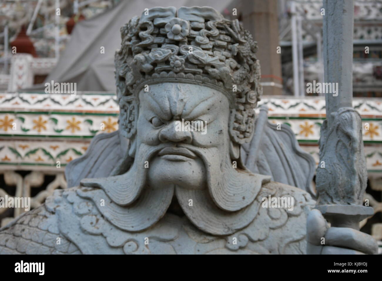 Eine steinerne Statue eines heftigen aussehenden chinesischen Wächter am Eingang des Wat Arun, Bangkok, Thailand. Stockfoto