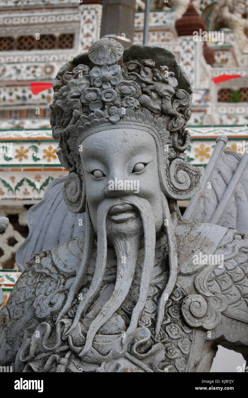 Eine steinerne Statue eines chinesischen Wächter am Eingang des Wat Arun, Bangkok, Thailand. Stockfoto