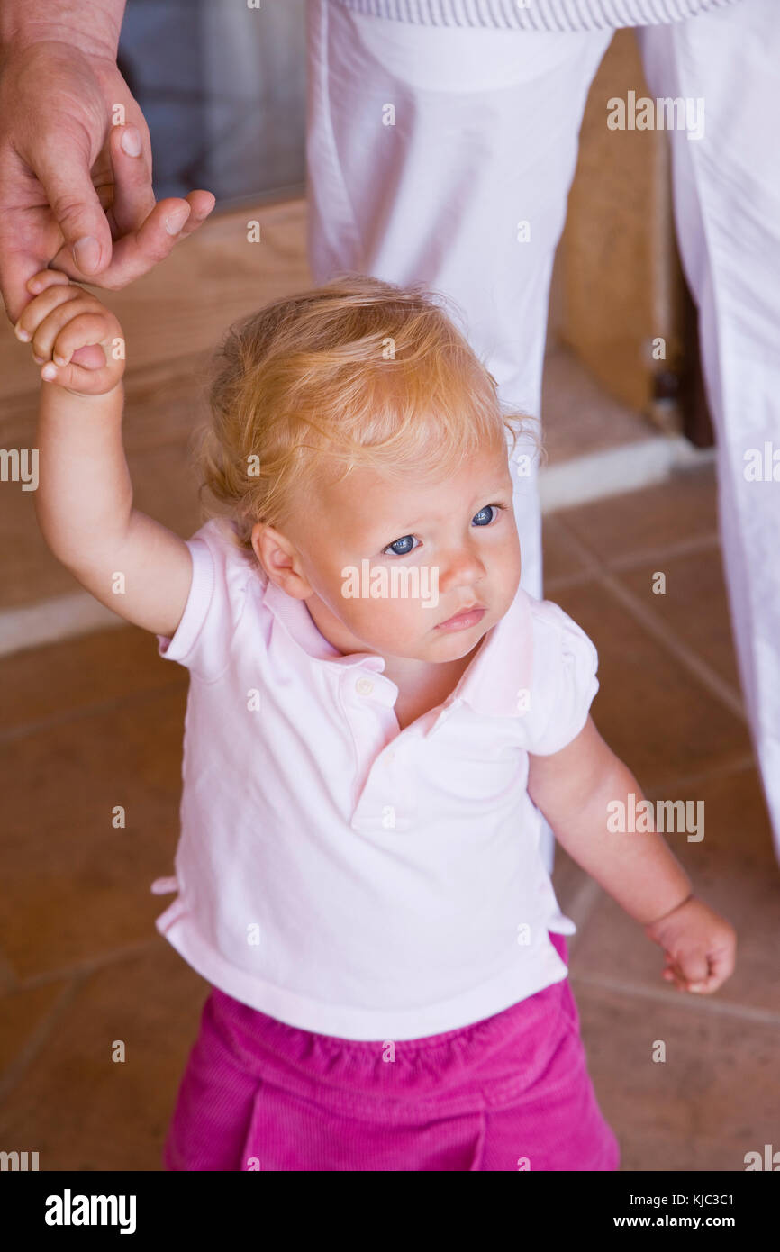 Kleines Mädchen mit dem Finger der Eltern Stockfoto