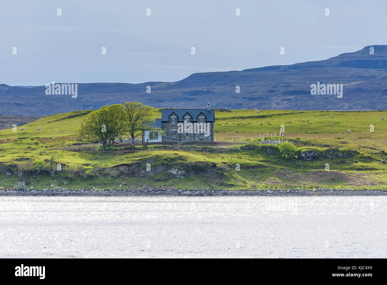 Meeresbucht mit typisch schottischem Wohnhaus im Dorf Dunvegan auf der Isle of Skye in Schottland, Großbritannien Stockfoto