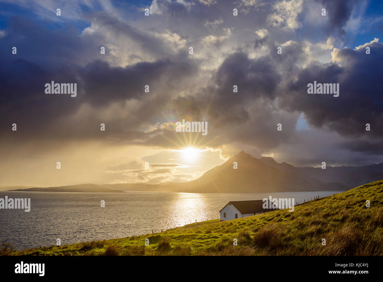 Dach eines Hauses entlang der schottischen Küste mit Sonne scheint durch die Wolken über Loch Scavaig, Isle of Skye in Schottland Stockfoto