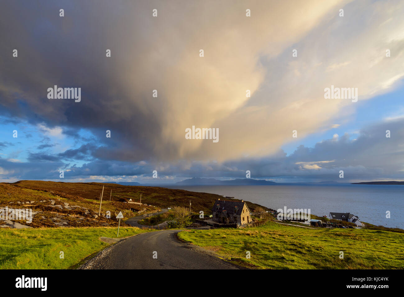 Straße zum Hafen mit Häusern am Hang und Sturmwolken über Loch Scavaig auf der Isle of Skye in Schottland Stockfoto