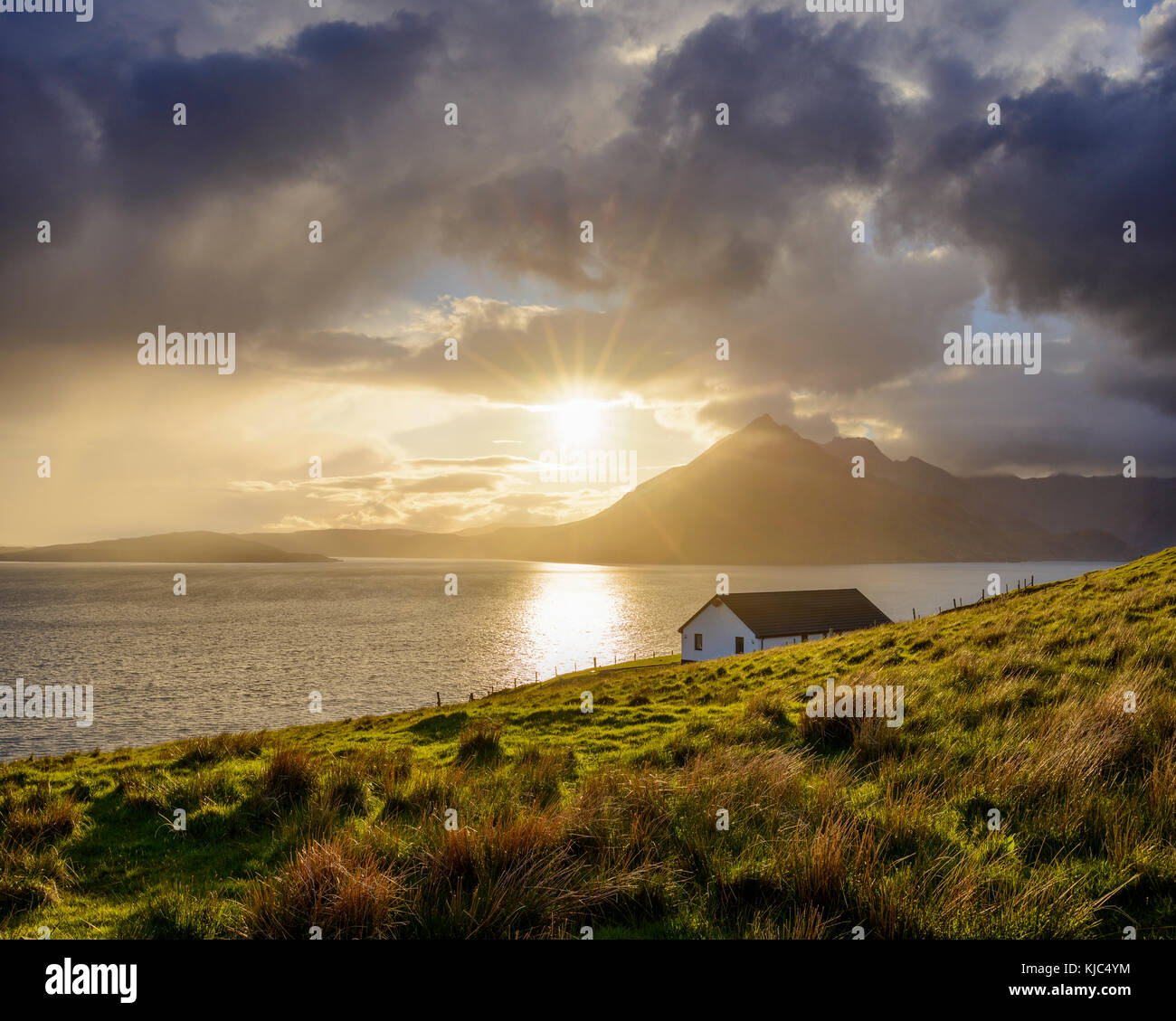 Dach eines Hauses entlang der schottischen Küste mit Sonne scheint durch die Wolken über Loch Scavaig, Isle of Skye in Schottland Stockfoto