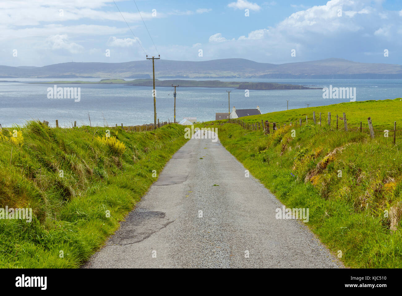 Einspurige Straße durch die Küstenlandschaft auf der Isle of Skye in Schottland, Großbritannien Stockfoto