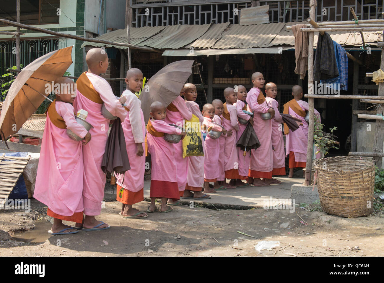 Birmanischen buddhistischen Anfänger Nonnen Warteschlange außerhalb eines Dorfbewohners Haus alms in pyay zu erhalten, Burma. Stockfoto