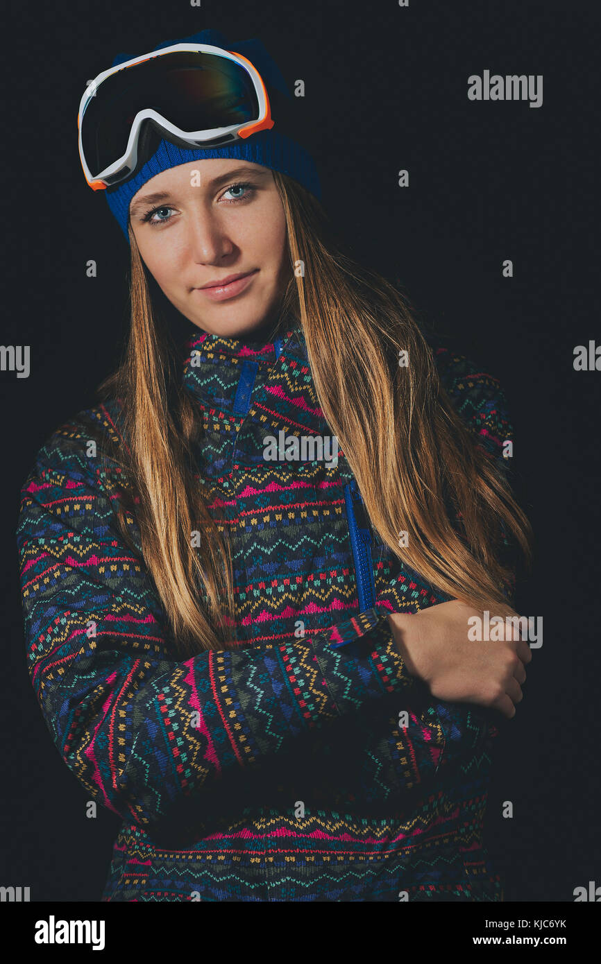 Schöne blonde Mädchen mit langem Haar in snowboard Bekleidung mit schwarzem Hintergrund. Stockfoto