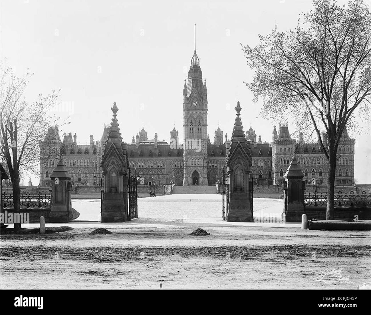 Dieser Blick auf den Parliament Hill in Ottawa, Kanada, zeigt die berühmten Regierungsgebäude, darunter den Centre Block und den Peace Tower. Die Perspektive ist von den Toren aus und zeigt die großartige Architektur des kanadischen Parlaments. Stockfoto