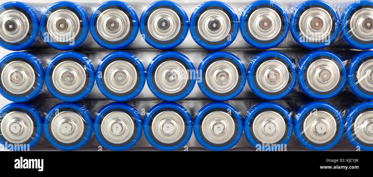 Viele blaue Batterien, Typ AA, in PE-Folie verpackt, auf einem weißen Hintergrund, Makro Stockfoto