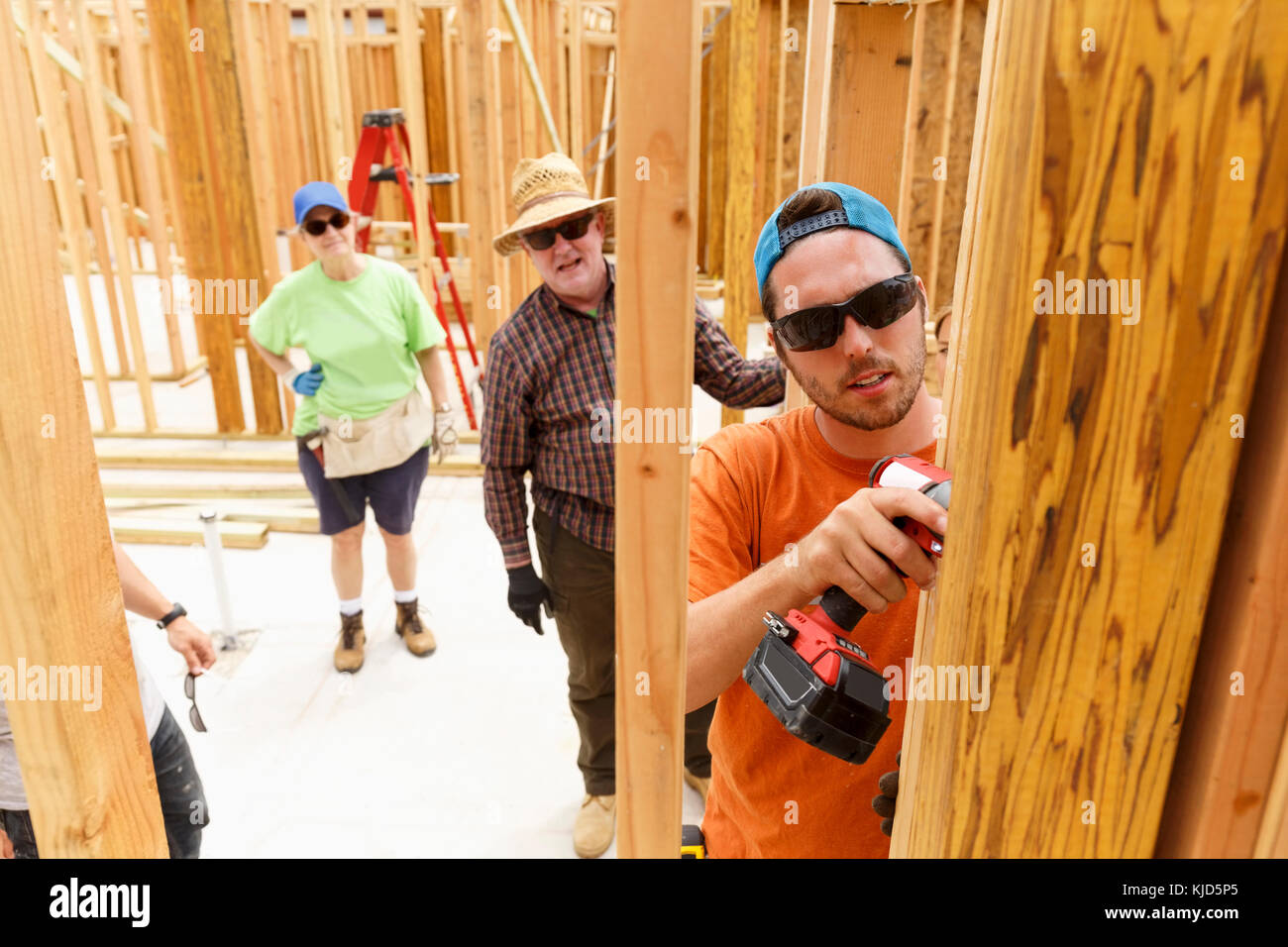 Freiwillige mit der Bohrmaschine auf der Baustelle Stockfoto