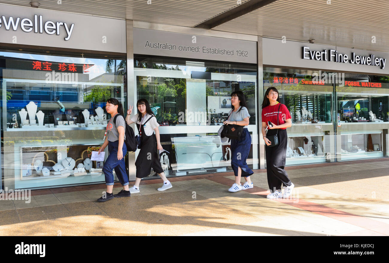 Lächelnden jungen chinesischen Touristen zu Fuß durch die Straßen von Cairns, Far North Queensland, FNQ, QLD, Australien Stockfoto