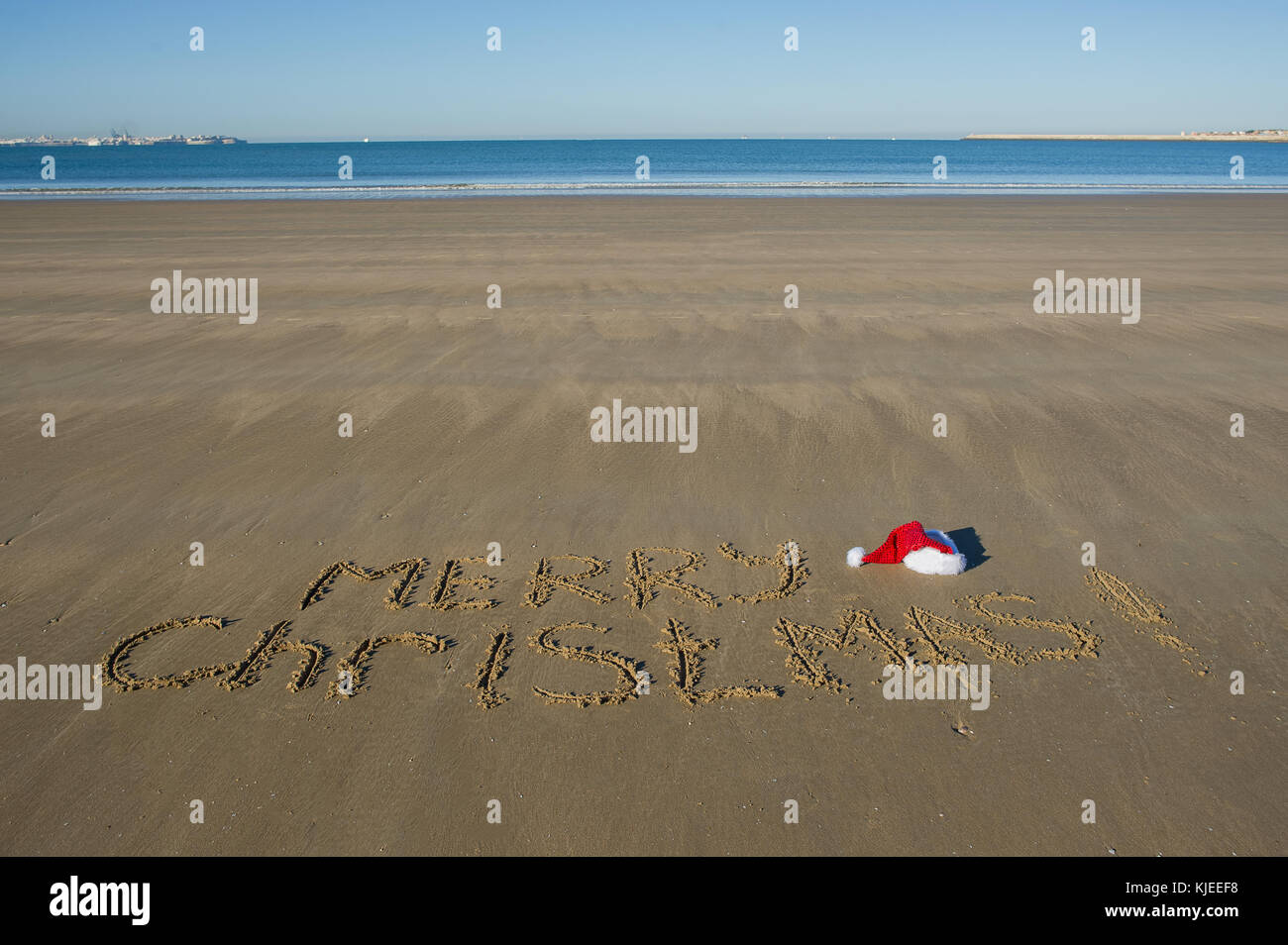 Frohe Weihnachten! Jemand hat eine herzliche Gratulation am Meer Sand