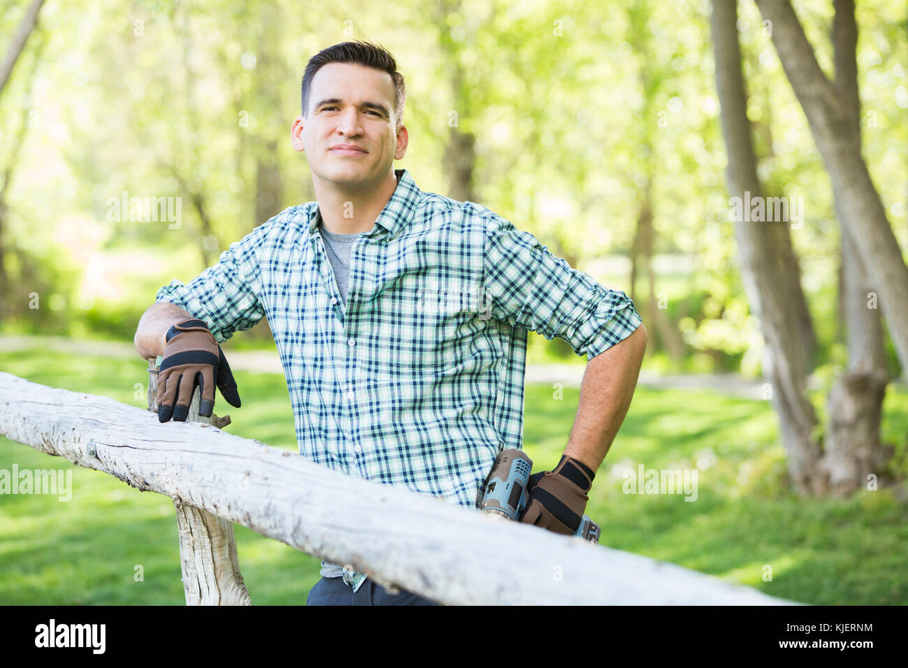 Gemischten rennen Mann mit Bohrer Reinigung auf dem Holzzaun Stockfoto