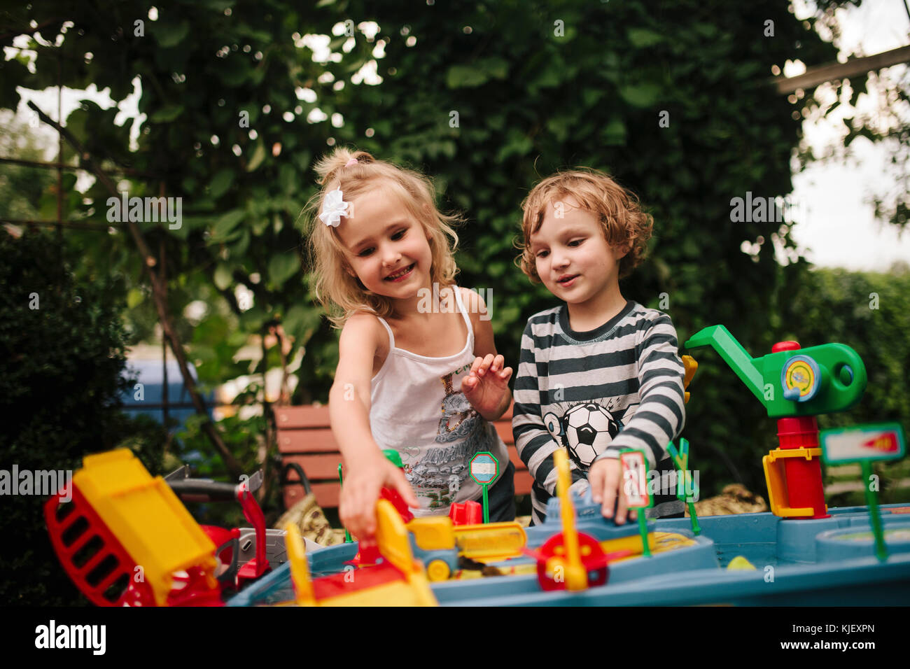 Kaukasische Junge und Mädchen mit Spielzeug spielen im Freien Stockfoto