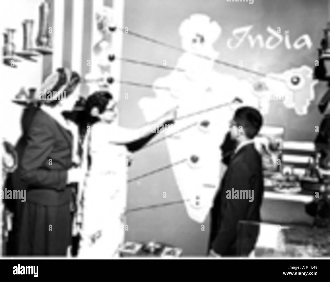 Die Gattin des Direktors der Indien Supply Mission erklären die Karte von Indien als interessierter Beobachter an der World Trade Exhibition Stockfoto