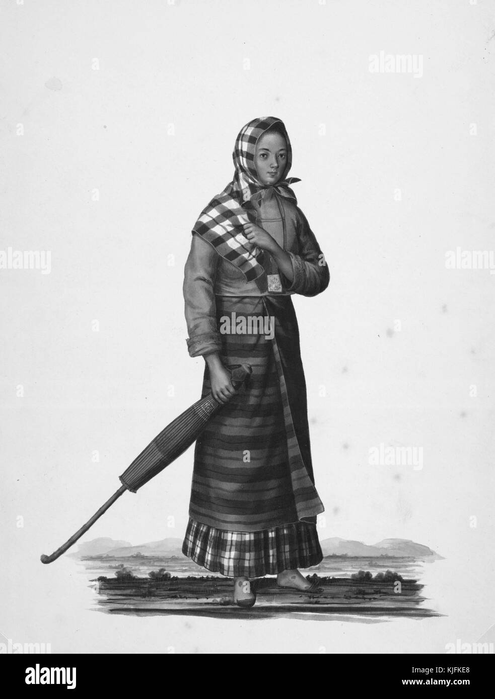Ein Gemälde einer philippinischen Frau, wie sie sich während der spanischen Kolonialzeit gekleidet hatte, trug Kleidungsschichten aus massiven blauen und gemusterten Stoffen, sie trägt einen breiten Schal über dem Kopf und trägt einen Regenschirm, sie wird auf einem offenen Grasfeld mit Bergen im Hintergrund gezeigt, 1841. Aus der New York Public Library. Stockfoto